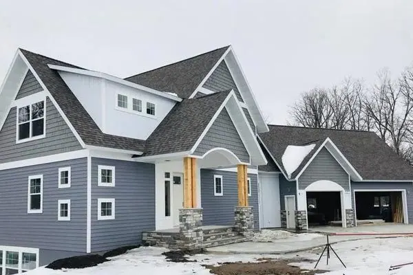 Two-story home with blue-gray lap siding, white trim and stone-wrapped porch columns