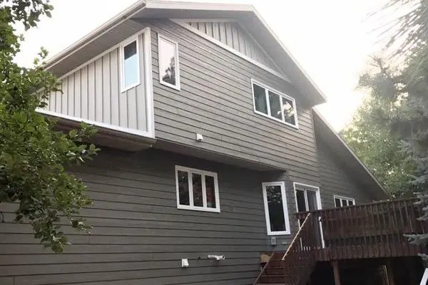 Two-story home with gray lap and board-and-batten siding and white windows